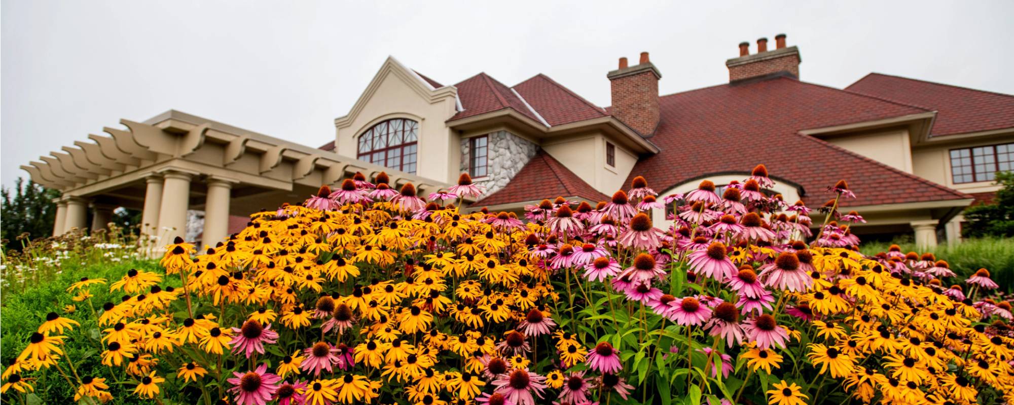 The Alumni House with colorful flowers in front.